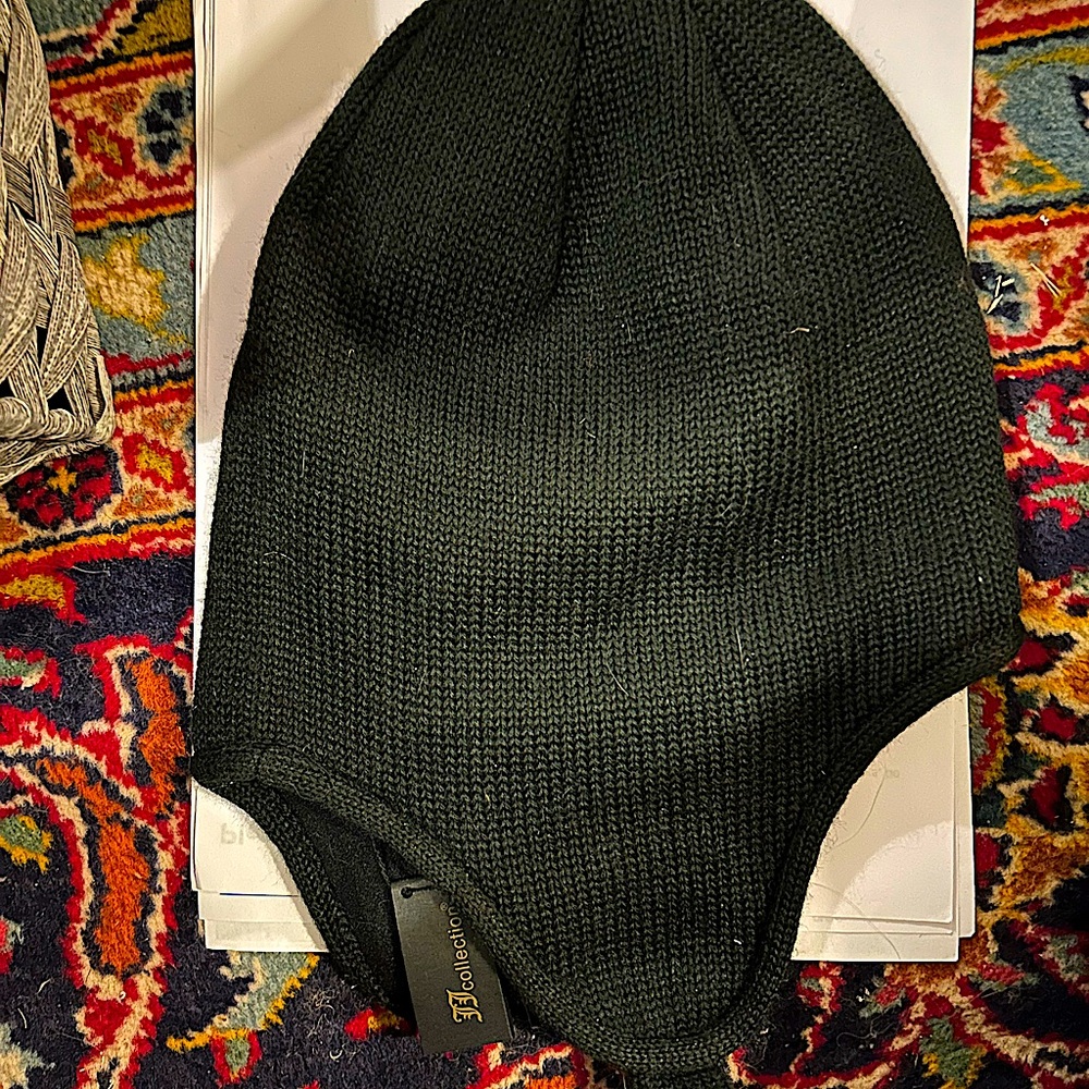Black Hat with chin strap.  Beige button on chin strap.